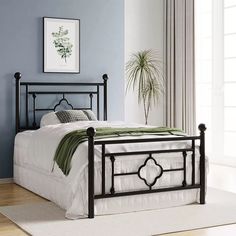 a black metal bed frame in a blue room with white carpeting and curtains on the window sill