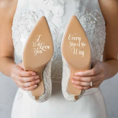 a bride holding her wedding shoes with the words i will love you on them