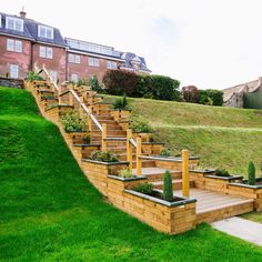 a set of wooden steps leading up to a house on top of a grassy hill