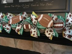 some footballs are tied to the mantle with ribbons and bows on it, along with other sports themed items