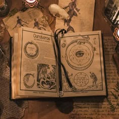 an open book sitting on top of a table next to a clock and other items