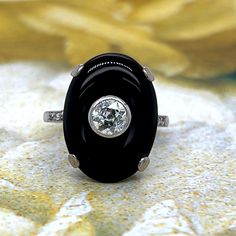 An exceptionally scintillating diamond and onyx cocktail ring. 18K white gold cocktail ring featuring an oval onyx cabochon, approx. 0.40 carats of old European cut diamond and rose cut diamonds at shank. Hallmark: No Hallmark, Tested for 18K Purity Metal Type: 18K White Gold Total Item Weight (g): 5.0 Gemstone: Old European-cut Diamond Color Grade: H-I Clarity Grade: SI1 Carat Weight: 0.40 Gemstone: Rose-cut Diamond Color Grade: H Clarity Grade: SI Gemstone: Onyx Stone Shape: Cabochon Stone Dim Art Deco Diamond Rings With Cabochon, Art Deco Diamond Cabochon Rings, Classic Diamond Cabochon Ring, Classic Diamond Ring With Cabochon Cut, Oval Diamond Jewelry With Black Enamel, Oval Black Enamel Diamond Jewelry, Heirloom Black Ring With Cabochon, Elegant Round Onyx Diamond Ring, Fine Jewelry Onyx Oval Ring