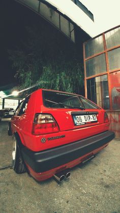 a red car parked in front of a building