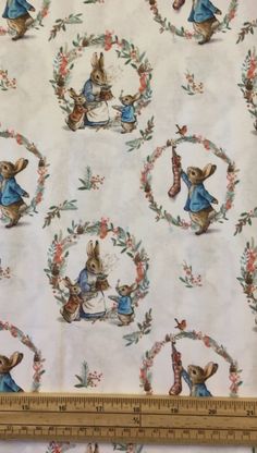 the fabric is white with blue rabbits and wreaths on it, as well as a ruler