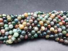 multicolored marble beads are stacked on top of each other in an arrangement,