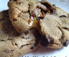 two chocolate chip cookies with melted butter on top are stacked up and ready to be eaten