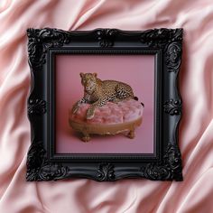 a framed photograph of a leopard laying on top of a doughnut