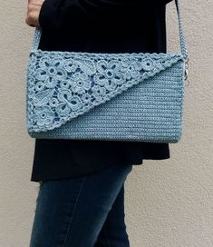 a woman carrying a crocheted blue purse