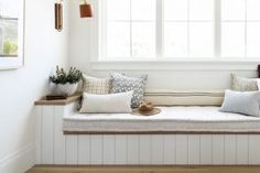 a white window seat with pillows on it