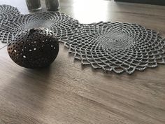 two pieces of doily sitting on top of a wooden table