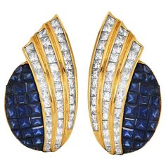 Opulent vintage late 1970s 18-karat yellow gold statement clip-on earrings Princess-Cut Diamond and Sapphire Statement Clip-On Earrings, Channel-Set Flair Design. Masterfully set within their gleaming contours are 6.40 carats of channel-set,  princess-cut natural diamonds, fashioned to flare with unbridled brilliance. Complementing this lustrous display are 4.56 carats of meticulously mystery-set square-cut natural sapphires, adding a profound depth of color to these luxurious earrings. These exquisite pieces are a celebration of refined craftsmanship and the timeless allure of fine gemstones. Secured with Clip-On closure. Measures 30mm x 15mm.  In Excellent Condition. Accompanied with official gemologist appraisal document. Flair Design, Luxurious Earrings, Luxury Earrings, Channel Set, Square Cut, Natural Sapphire, Princess Cut Diamonds, Princess Cut, Statement Earrings