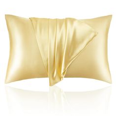 a gold satin pillow on a white background