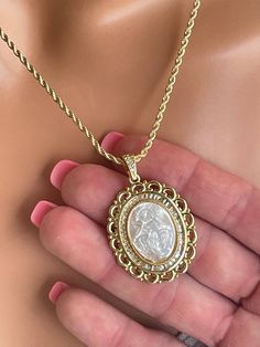 This is a beautiful extra large 18k gold filled Mary Miraculous pendant necklace for women.  This stunning pendant features the etched carving of mother of pearl shell surrounded with clear pave crystals. The lovely large cameo pendant comes on a beautiful 18k gold filled 2mm rope chain with spring clasp in back. Pendant measures 38x30mm and it is even more impressive in person!  Comes in a cute gift box! Luxury Gold Cameo Jewelry, Luxury Gold Cameo Necklace, Gold Intaglio Necklace, Gold Medallion Mother Of Pearl Jewelry, Gold Medallion Jewelry With Mother Of Pearl, Luxury Carved Gold Necklace, Gold Cameo Round Pendant Jewelry, Gold Mother Of Pearl Medallion Necklace, Gold Medallion Necklace With Mother Of Pearl