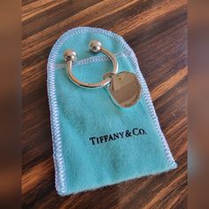 a tiffany & co ring on a blue towel sitting on top of a wooden table