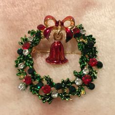 a christmas wreath brooch with a bell on it