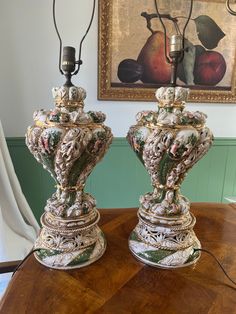 two ornate vases sitting on top of a wooden table