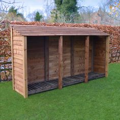 a wooden shed sitting on top of a lush green field