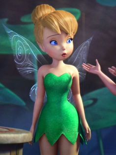 the tinkerbell fairy is standing next to a table