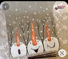 three snowmen with orange hats on their heads