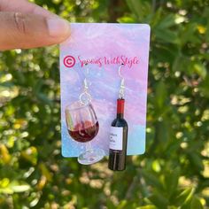 a person holding up a wine glass and bottle in front of a card with the word season wild style on it