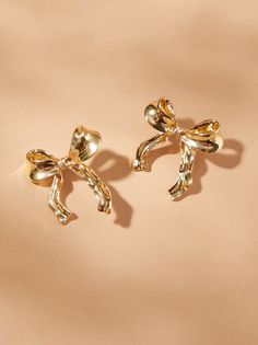 Add a hint of golden glamour to your look with our wavy detail bow earrings, featuring elegant waves for a touch of girly fun. Chic Formal Earrings, Chic Gold Earrings For Evening, Trendy Gold Earrings For Party, Trendy Gold Earrings For Evening, Gold Earrings With Decorative Bow For Formal Occasions, Gold Feminine Earrings For Party, Feminine Gold Earrings For Party, Formal Gold Earrings With Decorative Bow, Elegant Butterfly Knot Jewelry For Party