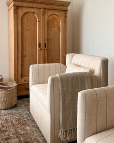 a living room with two couches and a cabinet in the corner next to it