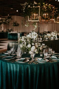 the table is set with white flowers and green linens for an elegant dinner party