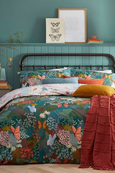 a bedroom with blue walls and colorful bedding