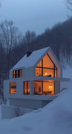 a large white house sitting on top of a snow covered hillside