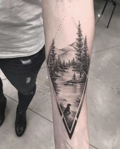 a person with a tattoo on their leg that has trees and mountains in the background