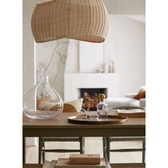 a wooden table topped with a vase filled with water and other items next to a fire place