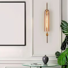 a glass table with a vase and plant on it in front of a white wall