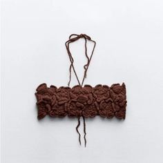 a piece of brown fabric is hanging on a white wall and there are no strings attached to it