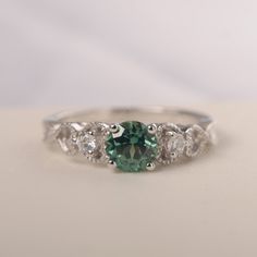 All HANDMADE ITEMS SHIP IN APPROX 8 DAYS Main Stone: Lab created green sapphire Main Stone Size: round cut 6 mm x 6mm Main Stone Weight: 1.02 carat Side Stone: CZs Height From The Ring Setting Bottom(to gemstone top): about 5.81 mm Width of Ring band Measure: gradually varied,about 1.79 to 4.89 mm Material: .925 Sterling Silver/14K White Gold/14K Yellow Gold/14k Rose Gold Engraved: Available For FreeNo more than 13 letters) Customized:Of course! Tell me what you want Includes With Order: All of Round Emerald Ring With Sapphire Accent Stones, Green Sapphire Jewelry With Center Stone, Green Sapphire Ring With Diamond, Green Sapphire Round Ring, Elegant Green Sapphire Ring With Halo Setting, Silver Sapphire Ring With Accent Stones For May Birthstone, Green Sapphire Ring With Halo Setting For Promise, Green Sapphire Jewelry With Halo Setting, Green Sapphire Diamond Ring With Round Cut