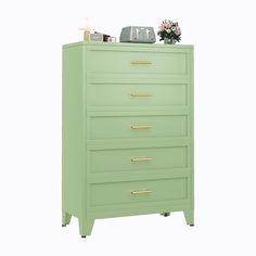 a green dresser with gold handles and drawers