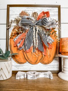 an orange pumpkin decorated with black and white stripes is sitting on a shelf next to a potted plant