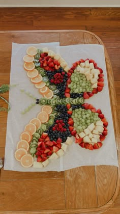 a butterfly made out of fruit on top of a white paper towel sitting on a wooden table