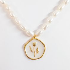 Indulge in the beauty of the Tulip Coin Pendant Pearl Necklace, a meticulously handcrafted piece featuring an enamel tulip flower delicately placed on thick gold-plated brass. The intricate detailing of the enamel work brings the tulip to life, while the lustrous seed pearl necklace adds a touch of elegance and sophistication. This necklace is a perfect fusion of artistry and quality, showcasing the beauty of nature and craftsmanship in a timeless piece that will be treasured for years to come. MATERIALS: Metal: Gold-plated Brass Pendant: Handmade Enamel Pearls: Natural Freshwater Pearl DIMENSIONS Natural stone & Pearl sizes may vary slightly. Necklace Length: 14.2 inches + 4.3 inches extension Pendant Length: 0.9 inches Width: 0.8 inches PROCESSING & SHIPPING All of my pieces are shipped Mother's Day Gold Enamel Jewelry, Gold Medallion Mother Of Pearl Jewelry, Gold Medallion Jewelry With Mother Of Pearl, Gold Medallion Necklace With Mother Of Pearl, Gold Medallion Necklace In Mother Of Pearl, Gold Mother Of Pearl Medallion Necklace, Gold Flower-shaped Jewelry With Pearl Charm, Gold Flower-shaped Enamel Jewelry, Gold Mother Of Pearl Flower Pendant Jewelry