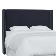 an upholstered headboard with white sheets and pillows on the bottom half of it