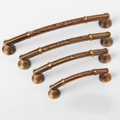 four antique brass door handles on a white background