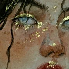 an artistic painting of a woman's face with gold glitter on it