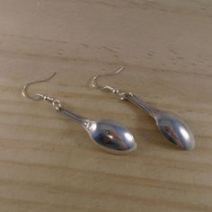 A simple yet quirky pair of earrings hand made from an old pair of silver plated sugar tongs. The spoon bowl ends of the tongs have been sawn off and then a hole has been drilled in the top so they can be attached to silver plated ear wires. Earring drop length approx 6cm Comes in an organza bag Please take a look at my other items Spoon Earrings, Vinyl Display, Organza Bags, Concept Store, Ear Wires, Jewelry Earrings Dangle, Silver Plate, Etsy Earrings, Silver Plated