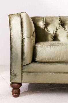 a gold colored couch sitting on top of a white floor