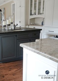 a kitchen with white cabinets and marble counter tops, along with an island in the middle