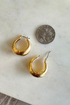 Heavyweight, hammered, metal hoops. Worn gold design that is shiny and texturized. Traditional latch closure that completes the hoop. Everyday Hammered Metal Hoop Earrings, Small Hammered Metal Hoop Earrings, Gold Hammered Metal Hoop Earrings, Chic Gold Hammered Hoop Earrings, Textured Small Hoop Metal Jewelry, Gold-tone Brass Hoop Earrings, Gold-tone Hoop Metal Jewelry, Hammered Metal Hoop Earrings, Hammered Metal