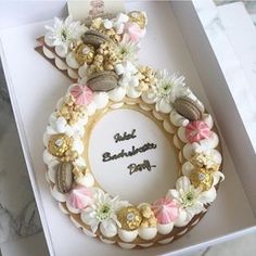 a birthday cake in a box with flowers and seashells on it's side