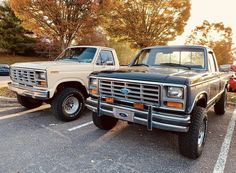 two pickup trucks parked in a parking lot