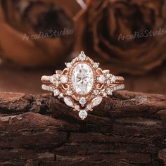 a close up of a ring on top of a wooden surface with roses in the background