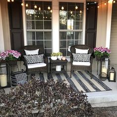 the front porch is decorated with wicker chairs and lanterns