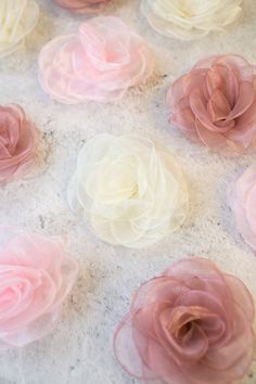 several pink and white flowers sitting on top of a marble countertop next to each other